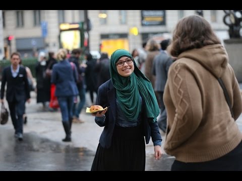 شاهد رد فعل المارة في السويد على فتاة محجبة تحمل لافتة أنا مسلمة